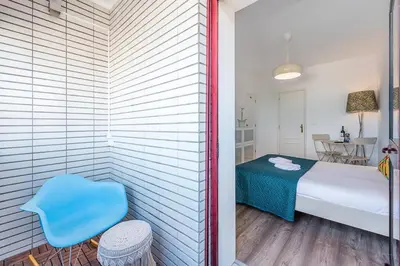 a bedroom with a bed and a blue chair at GuestReady - Red Stripes in Porto