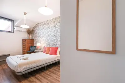 a bedroom with a bed and a mirror on the wall at GuestReady - Red Stripes in Porto