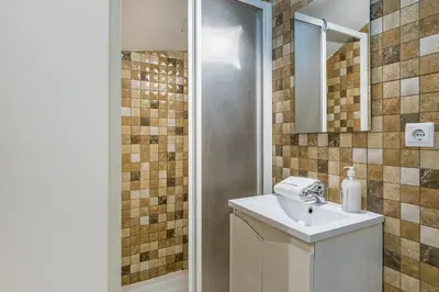 a bathroom with a sink and a shower with a mirror at GuestReady - Red Stripes in Porto