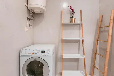 a laundry room with a washing machine and shelves at GuestReady - Red Stripes in Porto