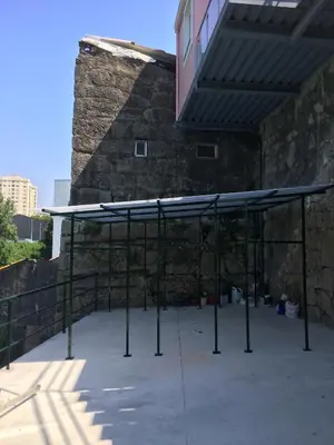 a canopy in front of a building with a stone wall at Maredimo Village Casa 6 in Porto