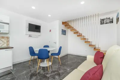 a living room with a couch and a table and chairs at Maredimo Village Casa 6 in Porto