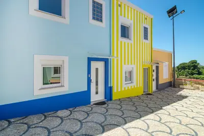 a blue and yellow building with doors and windows at Maredimo Village Casa 6 in Porto