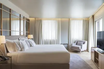 a bedroom with a large white bed and a television at Casa da Companhia Hotel & Spa, Vignette Collection by IHG in Porto