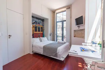 a bedroom with a bed with a train in the window at ON Apartments - Center in Porto