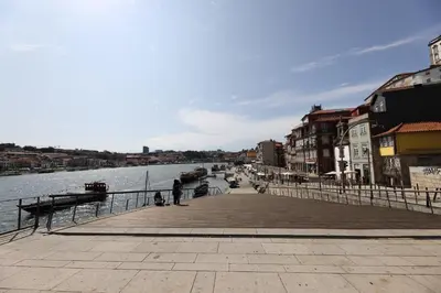 a boardwalk next to a body of water with buildings at FLH Porto Traditional Studio in Porto