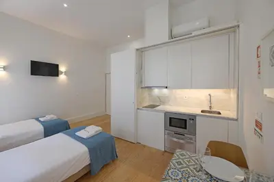a room with a bed and a kitchen with a sink at FLH Porto Traditional Studio in Porto