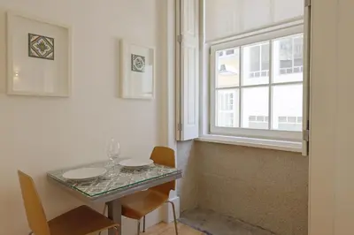 a dining room table with two chairs and a window at FLH Porto Traditional Studio in Porto