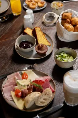 a wooden table topped with plates of food and drinks at Fontinha Porto, Trademark Collection by Wyndham in Porto