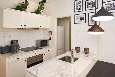 a kitchen with white cabinets and a marble counter top at BOUTIQUE Rentals-Flores Classic historical centre in Porto