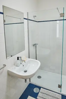a white bathroom with a sink and a shower at BOUTIQUE Rentals-Flores Classic historical centre in Porto