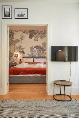 a bedroom with a bed and a flat screen tv at BOUTIQUE Rentals-Flores Classic historical centre in Porto