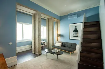a living room with a couch and a tv at Almada 234 in Porto