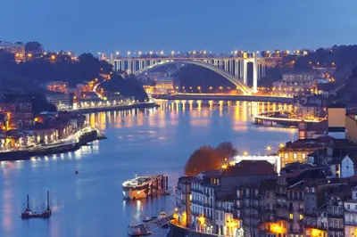 a view of a river at night with a bridge at Sol Downtown Studio with Juliet Balcony in Porto