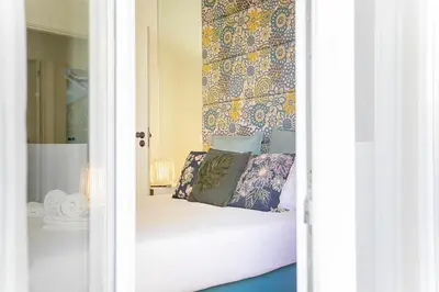 a bedroom with a bed with blue and yellow wallpaper at Oporto Flores Plaza by LovelyStay in Porto