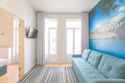 a living room with a blue couch in front of a window at Oporto Flores Plaza by LovelyStay in Porto