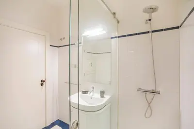 a white bathroom with a sink and a shower at Oporto Flores Plaza by LovelyStay in Porto
