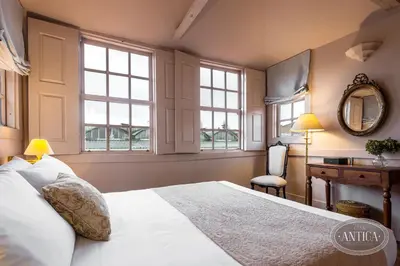 a bedroom with a bed and a desk and windows at Casa Antiga in Porto