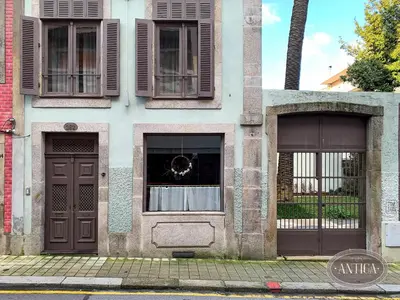 a building with two doors and windows on a street at Casa Antiga in Porto