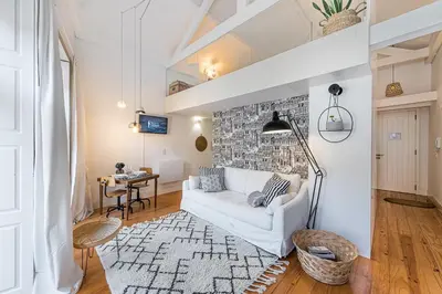 a living room with a white couch and a brick wall at GuestReady - Cosy living in downtown in Porto