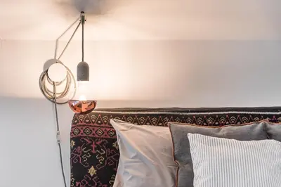a lamp hanging over a bed with pillows at GuestReady - Cosy living in downtown in Porto