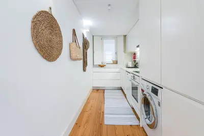 a white laundry room with a washer and dryer at GuestReady - Cosy living in downtown in Porto