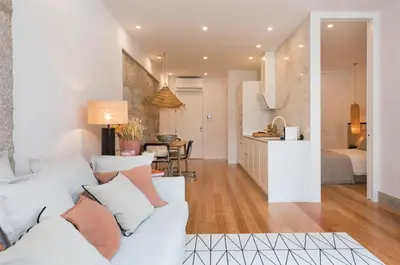 a living room with a white couch and a kitchen at GuestReady - The Dukes Retreat E in Porto