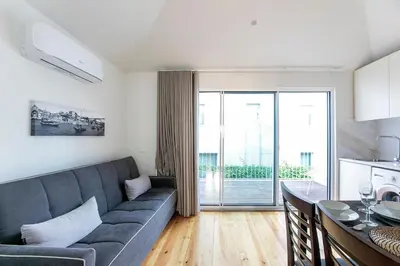 a living room with a gray couch and a table at LovelyStay - Cozy 1BR in Santa Catarina w/ Balcony in Porto