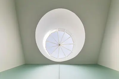 a round window in a room with white walls at LovelyStay - Cozy 1BR in Santa Catarina w/ Balcony in Porto