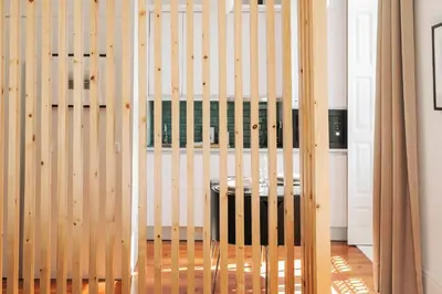 a wooden partition with a stool in a room at Oportments - S.Bento in Porto