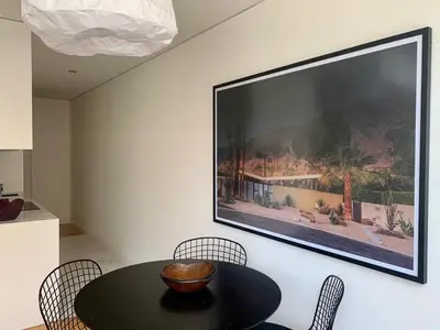 a television hanging on a wall with a table and chairs at Oporto Chic & Cozy - Santa Catarina in Porto