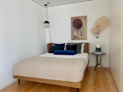 a bedroom with a bed with a blue pillow on it at Oporto Chic & Cozy - Santa Catarina in Porto