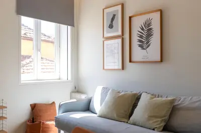 a living room with a blue couch and two windows at Prime Riverside in Porto
