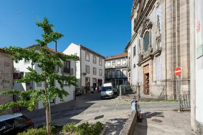 a woman walking down a street in a town at Prime Riverside in Porto