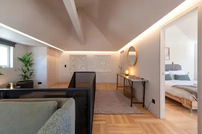 a bedroom with a bed and a living room with a couch at Prime Riverside Duplex in Porto