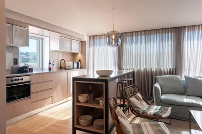 a kitchen and living room with a table and chairs at Prime Riverside Duplex in Porto