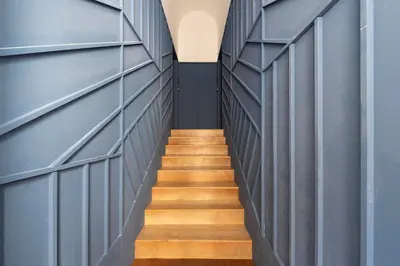 a hallway with blue walls and wooden stairs at Prime Riverside Duplex in Porto