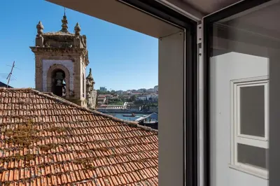 a view from a window of a tile roof with a tower at Prime Riverside Duplex in Porto