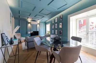 a blue living room with a glass table and chairs at Ribeira Old Town Charming Flat w/ AC by LovelyStay in Porto