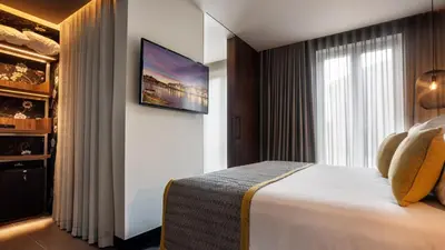a hotel room with a bed and a tv on a wall at Pousada do Porto - Rua das Flores in Porto