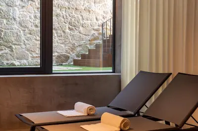 a chair with towels on a table in a room at Pousada do Porto - Rua das Flores in Porto