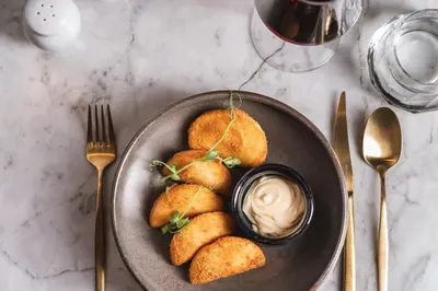 a plate of food with dipping sauce on a table at Pousada do Porto - Rua das Flores in Porto