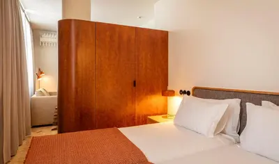 a bedroom with a bed with a wooden headboard at Ceuta Terrace Suites in Porto