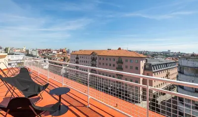 a balcony with two chairs and a view of a city at Ceuta Terrace Suites in Porto