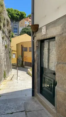 a green door on the side of a building at My Little Porto - Charming house in Miragaia, Porto in Porto