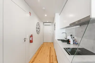 a kitchen with white counters and a wooden floor at GuestReady - Private oasis for two in Porto