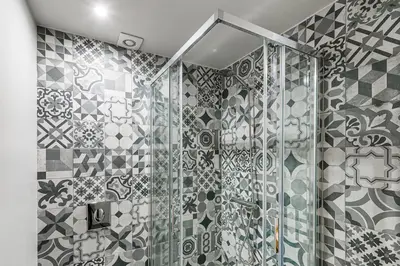 a bathroom with a shower with tiled walls at GuestReady - Private oasis for two in Porto