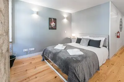 a bedroom with a large bed and a wooden floor at GuestReady - Private oasis for two in Porto