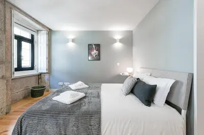 a bedroom with a large bed with white sheets and pillows at GuestReady - Private oasis for two in Porto