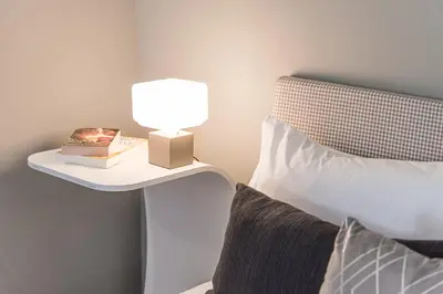 a lamp on a side table next to a bed at GuestReady - Private oasis for two in Porto